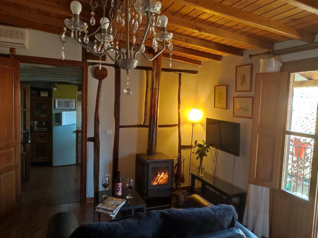 un soggiorno con divano e camino di Alojamientos La Herrera a San Esteban de la Sierra