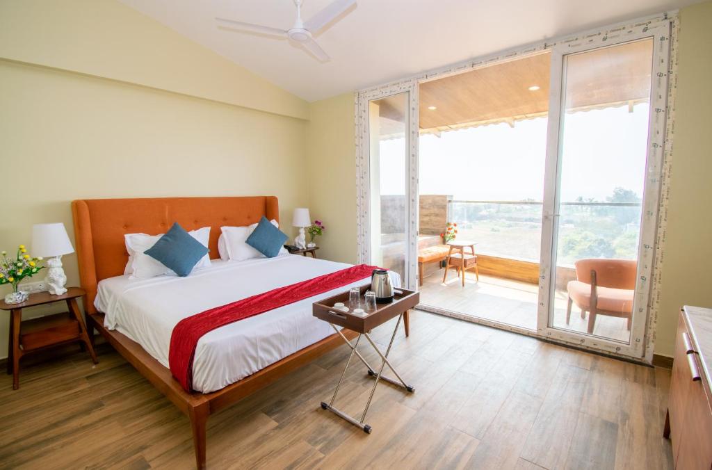 a bedroom with a bed and a large window at Octave Rococco Morjim in Goa Velha