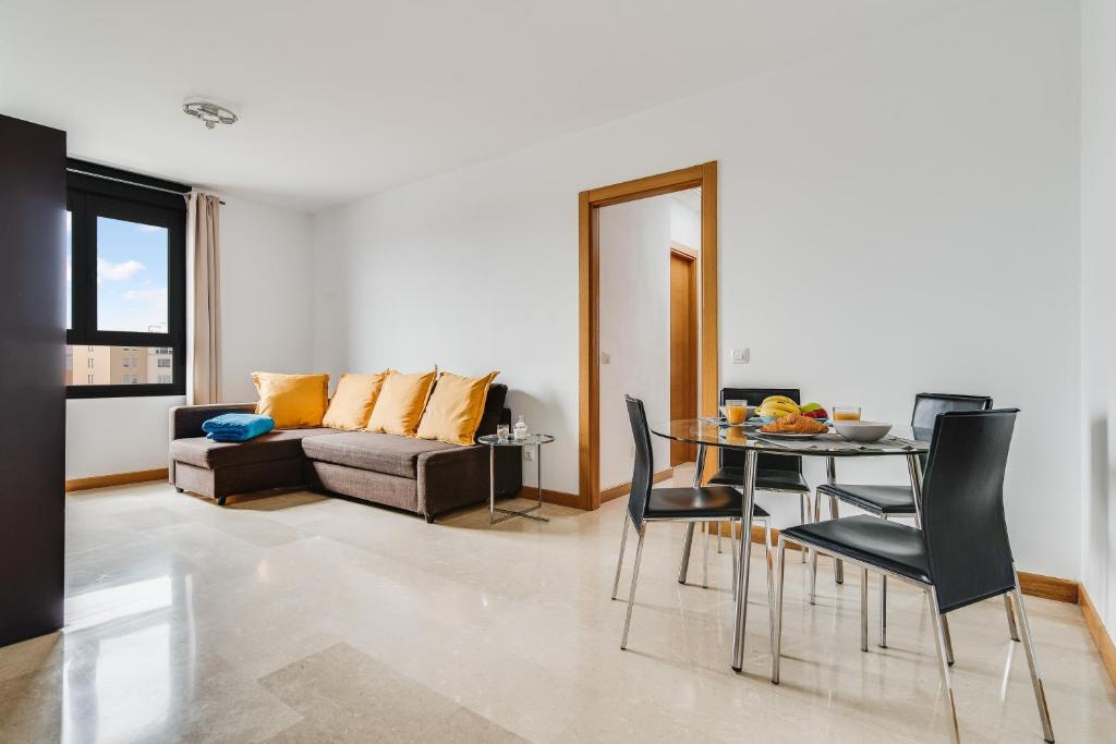 un soggiorno con divano, tavolo e sedie di Home2Book Comfy Apartment Siete Palmas a Las Palmas de Gran Canaria