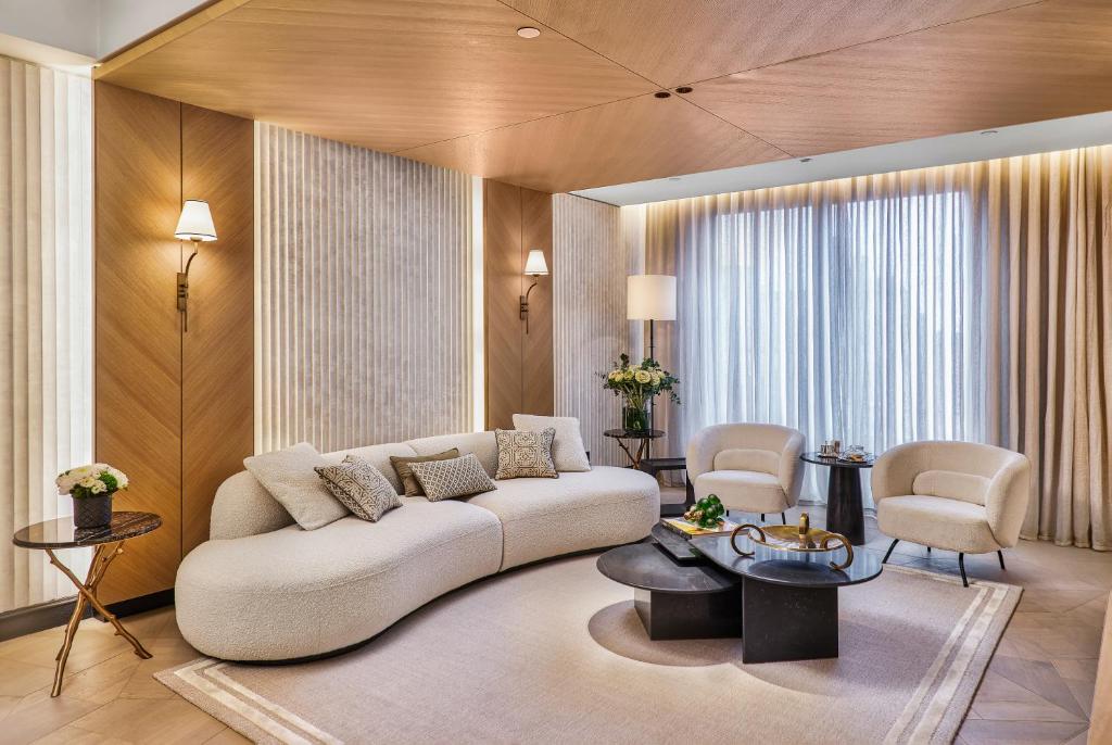 uma sala de estar com um sofá branco e cadeiras em Vakko Hotel and Residence em Istambul
