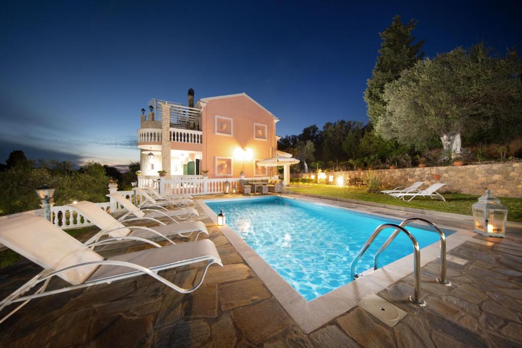 uma casa com piscina à noite em Villas Eleonas em Faiakes