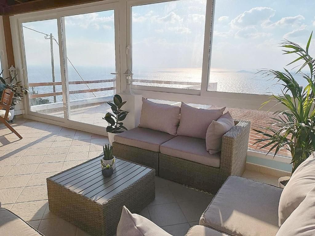 a living room with a couch and a view of the ocean at Villa Vista in Ermoupoli