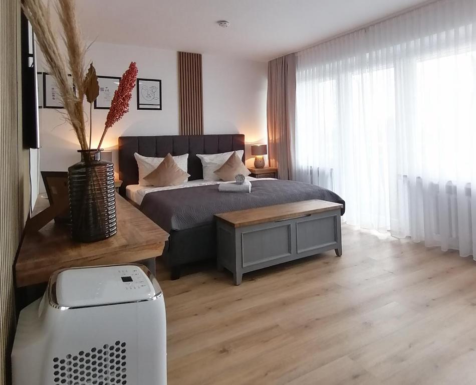 a bedroom with a bed and a table and a refrigerator at SKY INN - nahe Messe contactless check in in Hannover