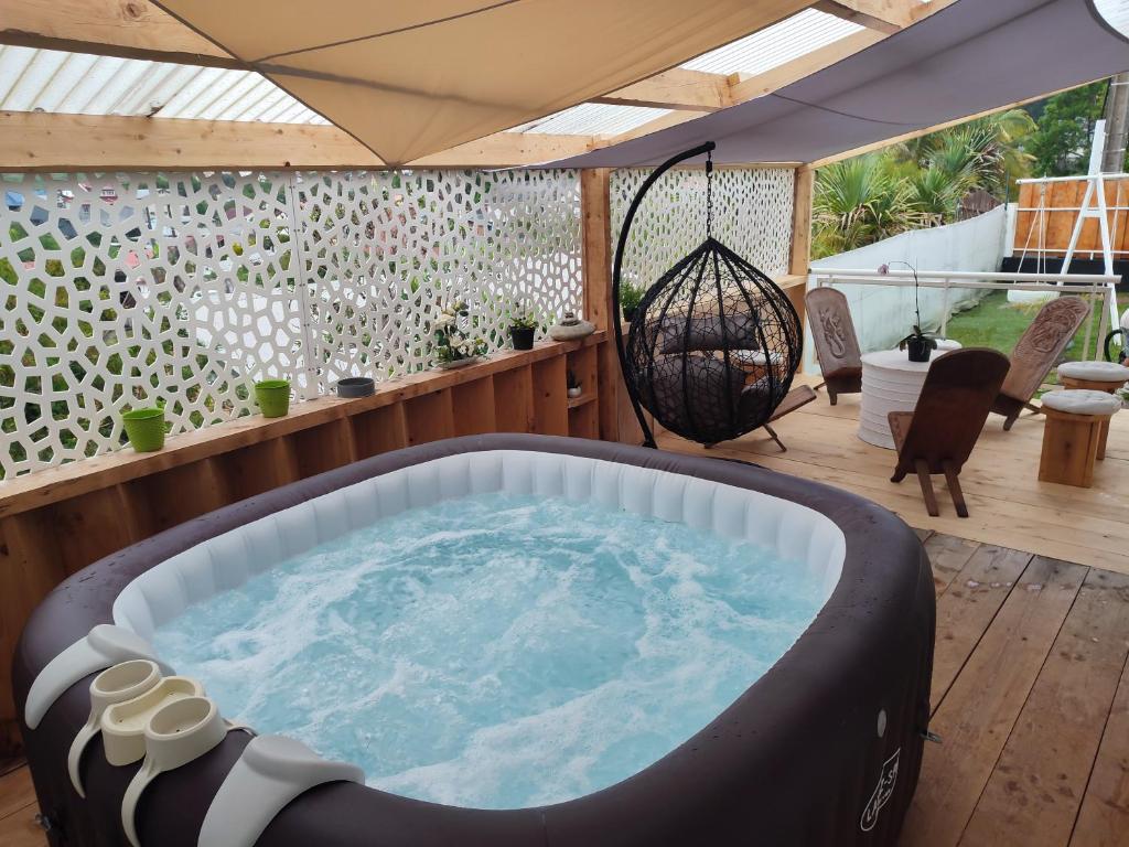 eine Whirlpool-Badewanne in der Mitte einer Terrasse in der Unterkunft Ti kaz mignon 974 in Saint-Louis