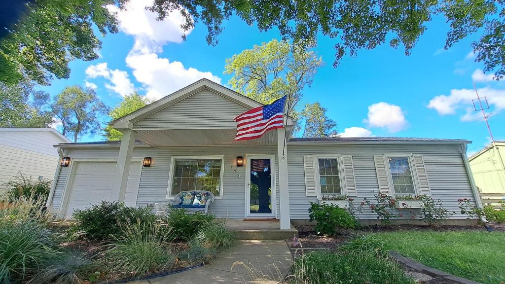 een huis met een Amerikaanse vlag ervoor bij Beachcomber in New Buffalo
