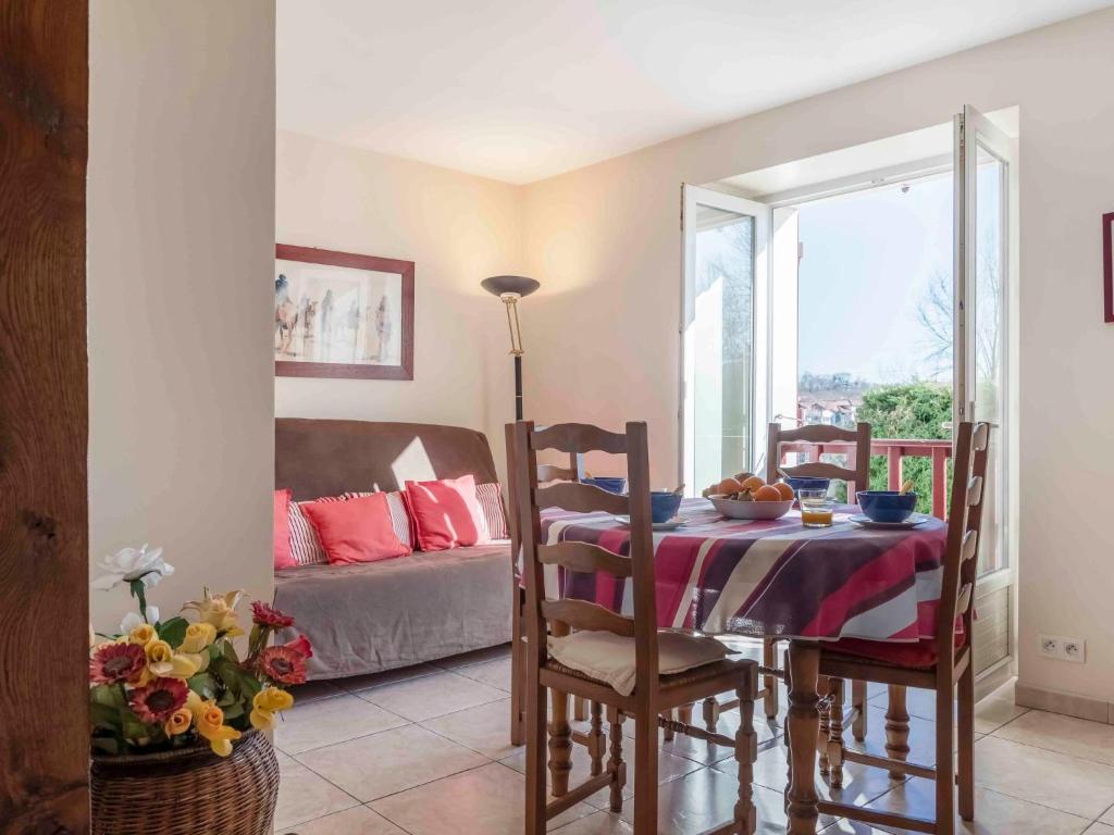 a dining room with a table and a couch at Apartment Kafartenea by Interhome in Urrugne