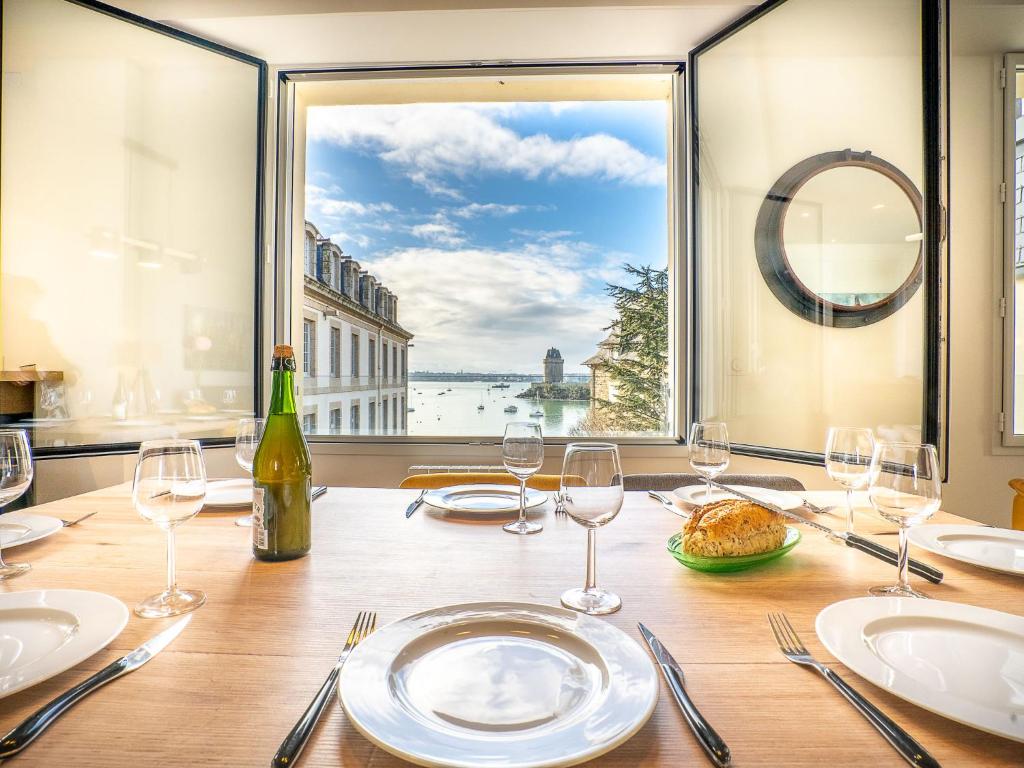 une table avec des verres à vin et une vue sur l'eau dans l'établissement Apartment Vue Solidor-2 by Interhome, à Saint-Malo