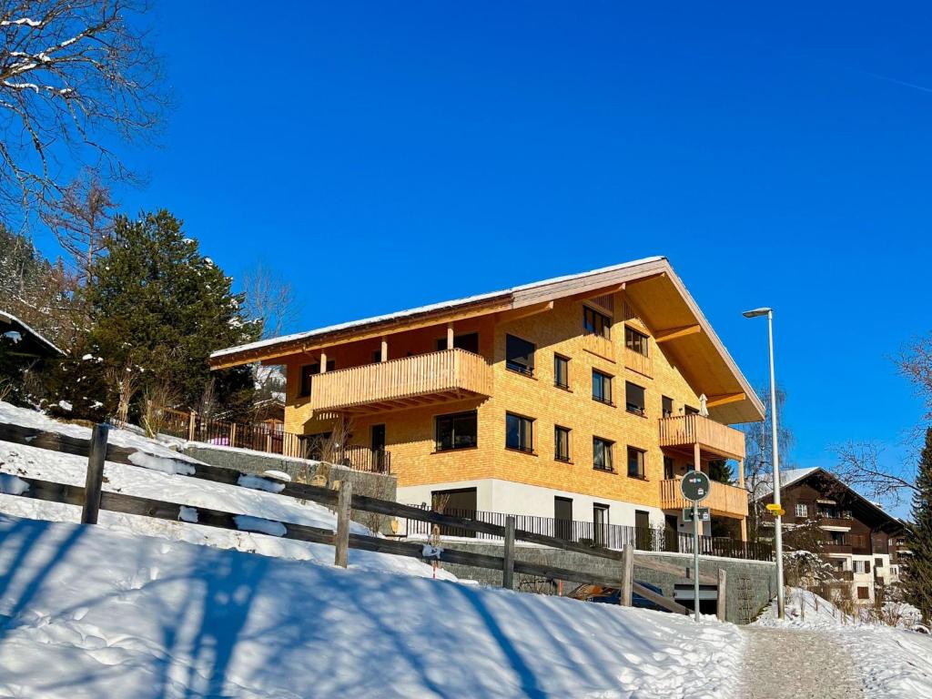a building with a fence in the snow at Apartment Sparenmoos - OB - DG Süd-West by Interhome in Zweisimmen