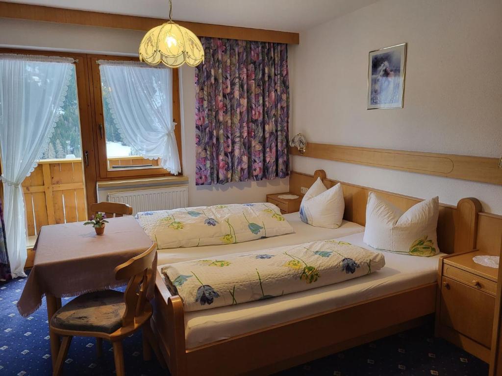 a bedroom with two beds and a table and a window at Apartment LaFontana by Interhome in Kappl