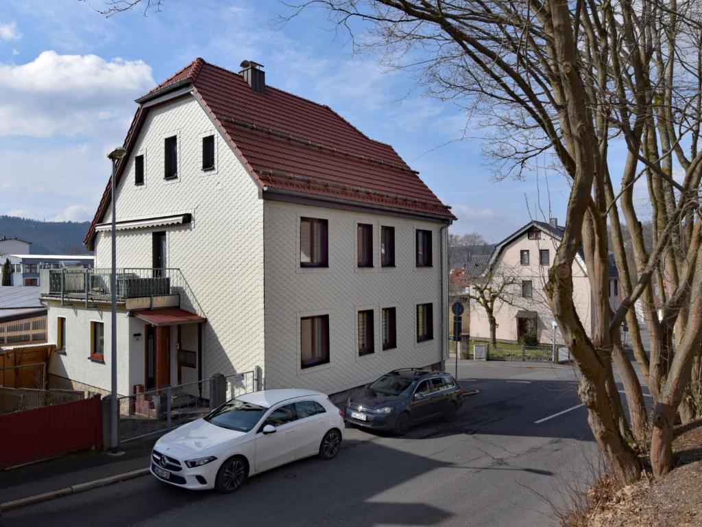 una casa blanca con un coche aparcado delante de ella en Apartment Carola by Interhome, en Zella-Mehlis