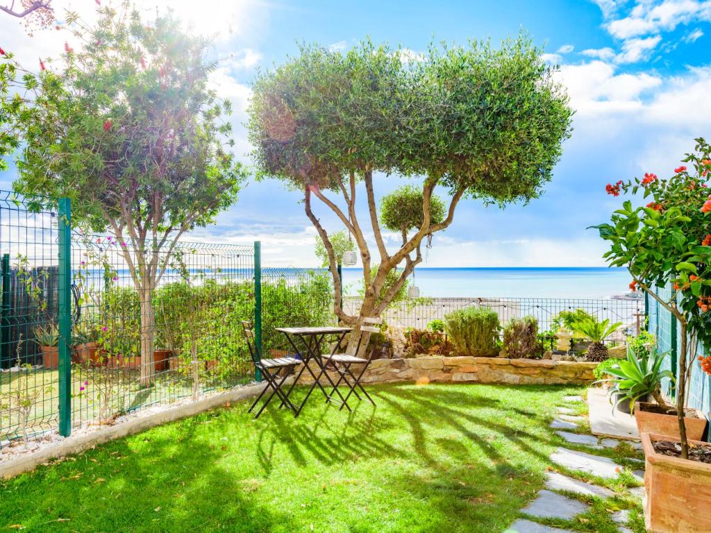 un jardín con una mesa, árboles y el océano en Holiday Home Casa Brisa Mar by Interhome, en Peñíscola