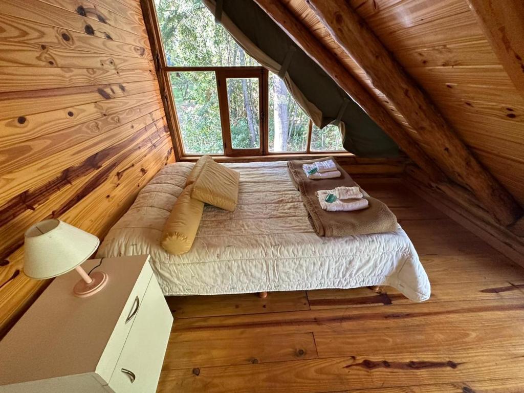 a bedroom in a log cabin with a bed at Cabaña en Parque Nacional Los Alerces in Esquel