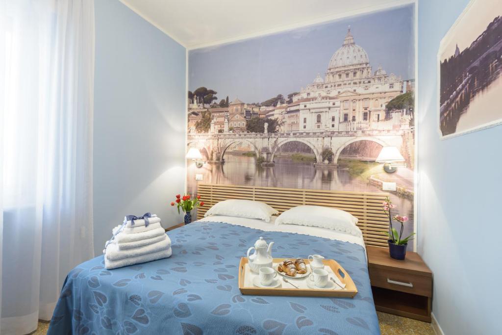 ローマにあるB&B Ad Maiora Romaの青いベッドと首都の絵画が備わるベッドルーム1室