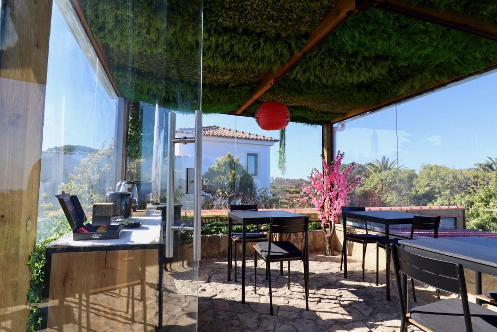 a patio with tables and chairs and a pool table at Penedo Escape Sea Suites in Colares