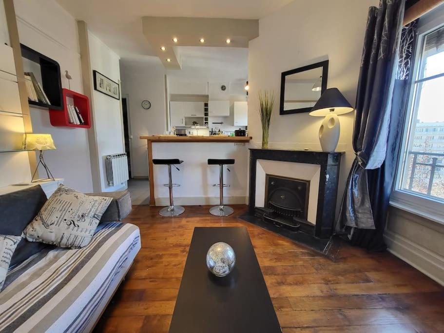 un salon avec un canapé et une cheminée dans l'établissement Stop Chez M Style # Qualité # Confort # Simplicité, à Lyon