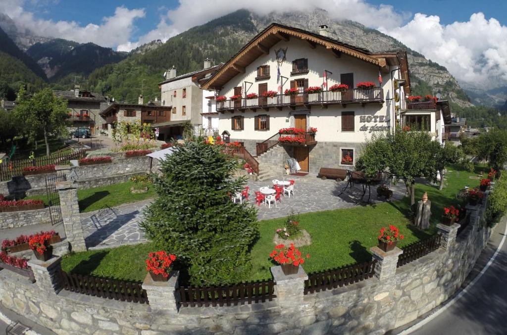 a building with a garden in front of it at Hotel Des Glaciers in Courmayeur