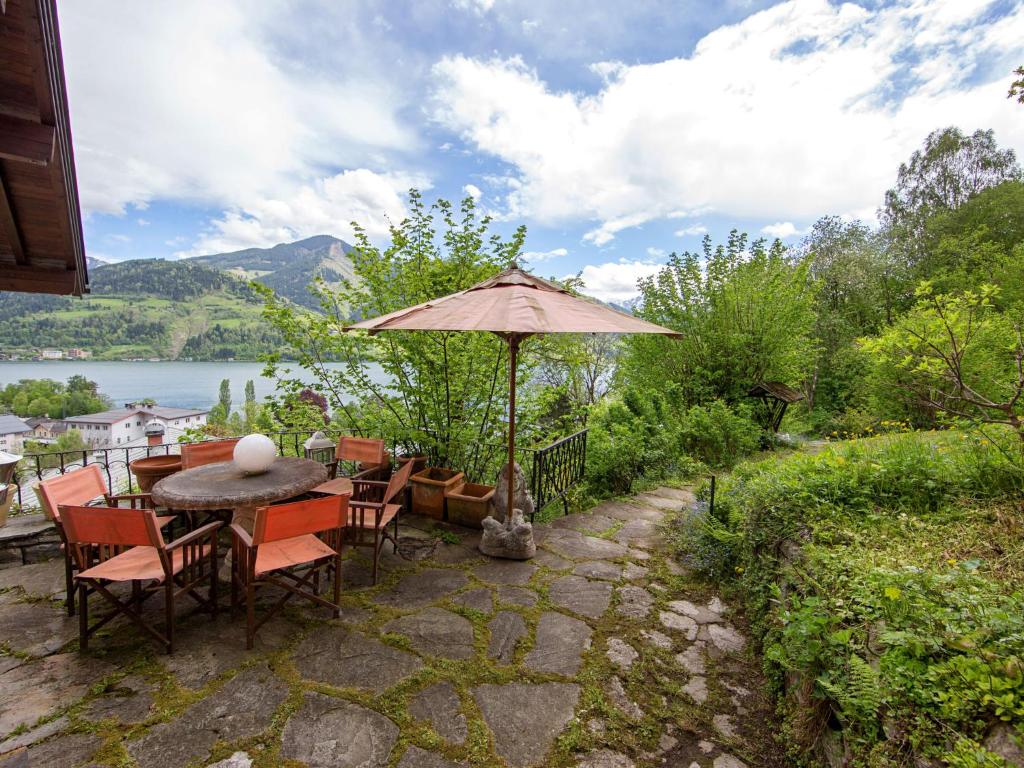 a patio with a table and chairs and an umbrella at Holiday Home Karin by Interhome in Zell am See