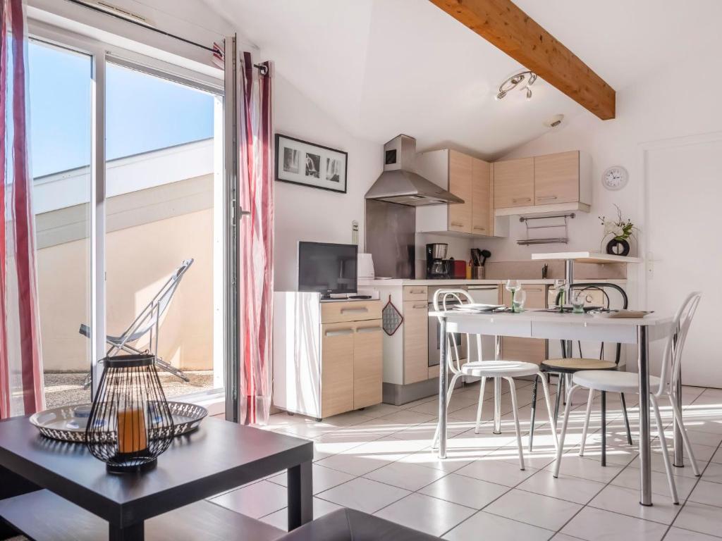 eine Küche und ein Esszimmer mit Tisch und Stühlen in der Unterkunft Studio Camijeanne by Interhome in Capbreton