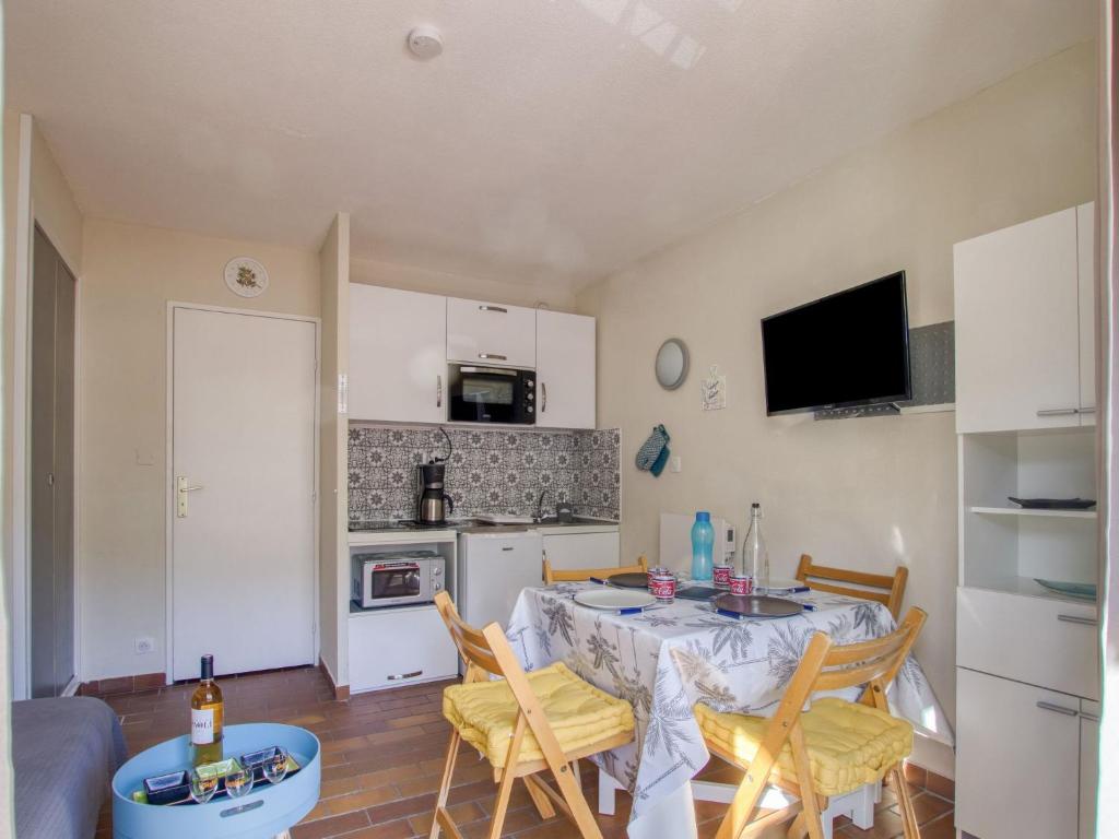kuchnia i jadalnia ze stołem i krzesłami w obiekcie Studio Les Aigues Marines-65 by Interhome w mieście Saint-Cyr-sur-Mer