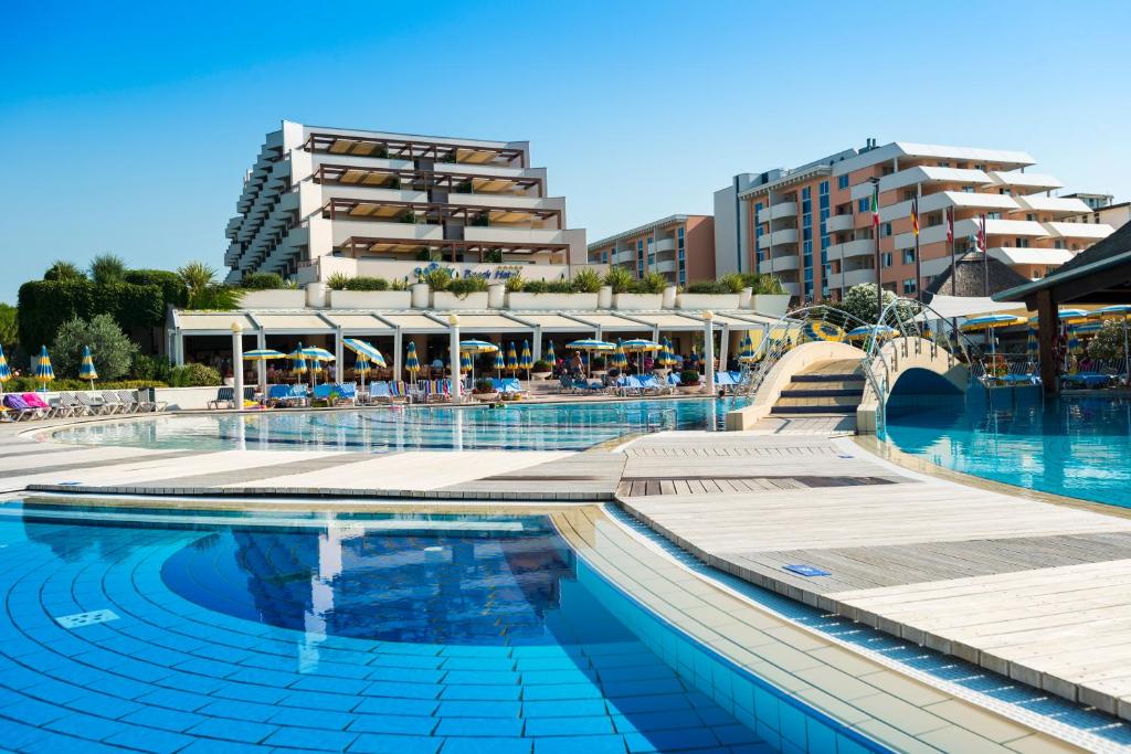 a swimming pool with a building in the background at Savoy Beach Hotel & Thermal Spa in Bibione
