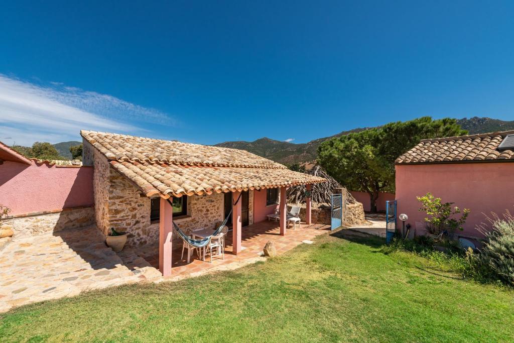 una casa in pietra con tetto e cortile di Villa Bella Solanas - Cuili Murvoni a Solanas