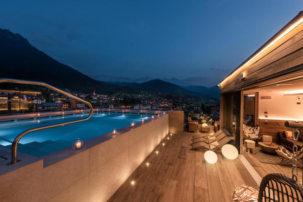 a swimming pool on the roof of a house at Brunet - The Dolomites Resort in Fiera di Primiero