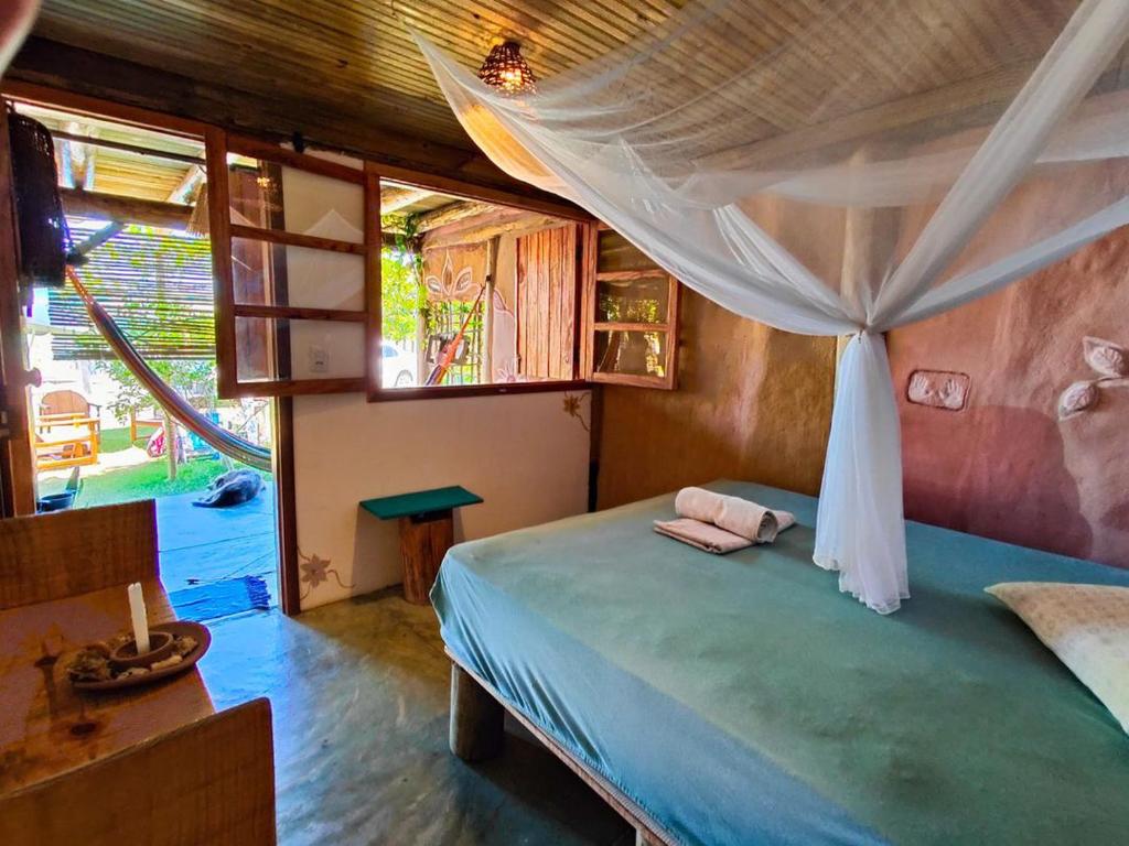 a bedroom with a bed with a canopy at Casa de Terra in Caraíva