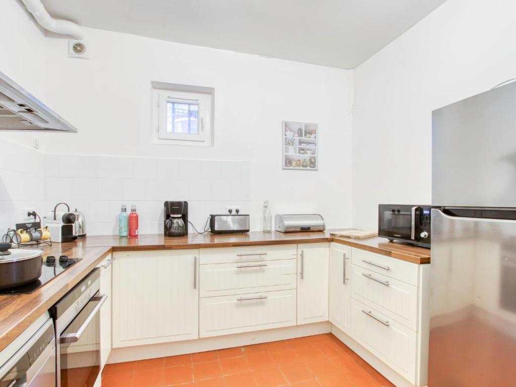 a kitchen with white cabinets and white appliances at Apartment la Rainette by Interhome in La Madrague