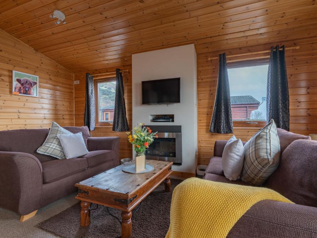 ein Wohnzimmer mit 2 Sofas und einem Couchtisch in der Unterkunft Chalet Loch Leven Lodge 10 by Interhome in Kinross