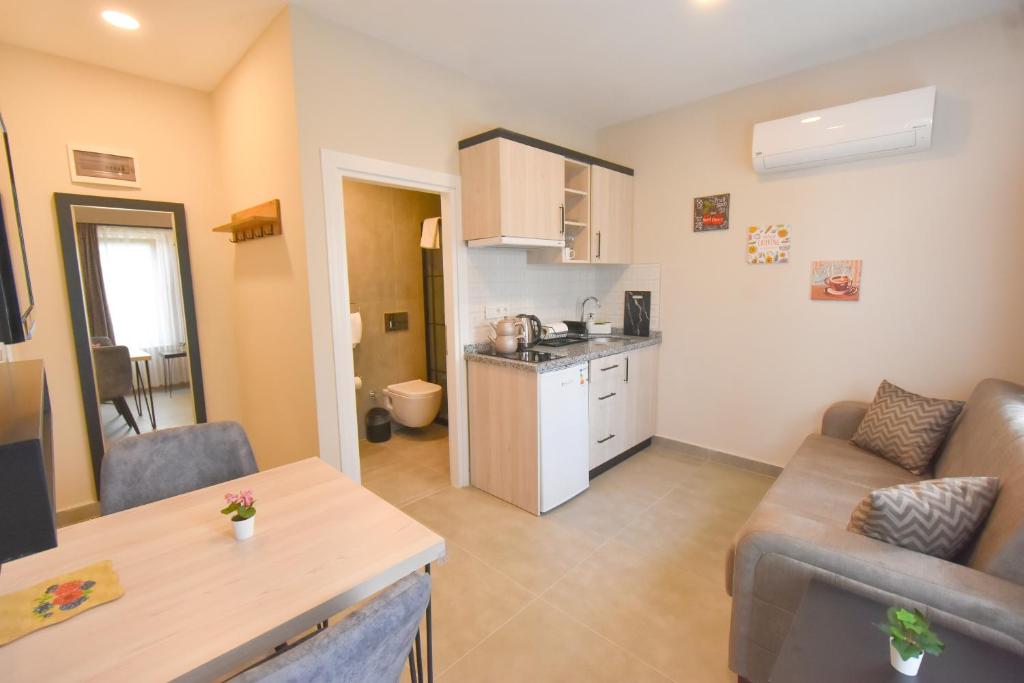 ein Wohnzimmer mit einem Sofa und einer Küche in der Unterkunft Beyaz Melek Apart Hotel in Antalya