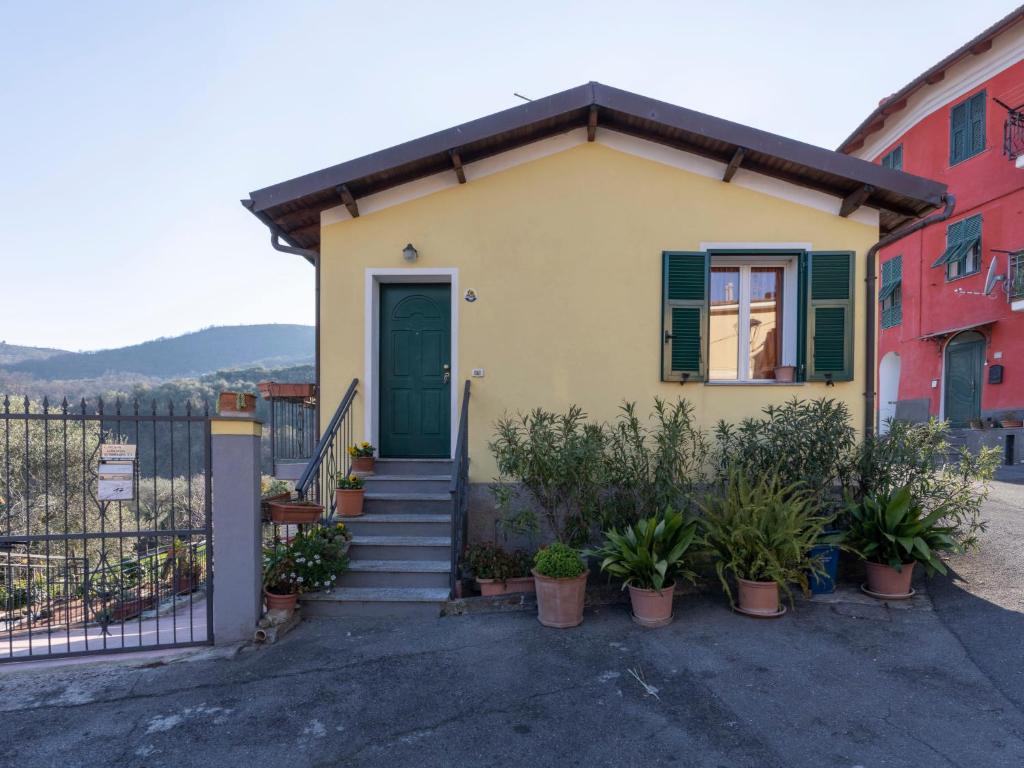 a small yellow house with a green door at Holiday Home Lory House by Interhome in Villa Viani