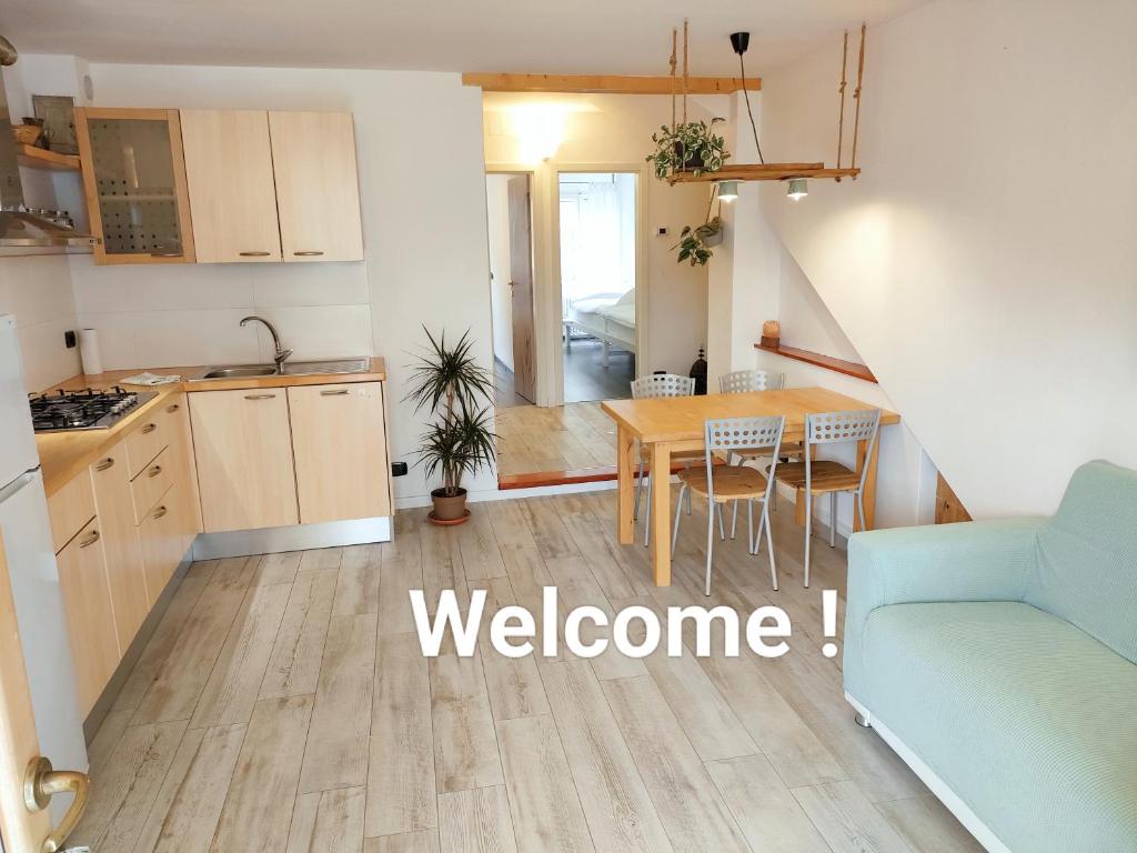 Una cocina y una sala de estar con una mesa y un sofá. en Garda Sweet Apartments, en Arco