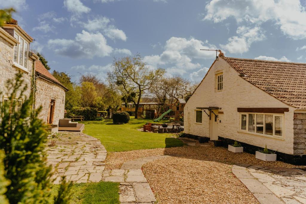 a house with a stone pathway leading to a yard at Little England Retreats - Cottage, Yurt and Shepherd Huts in Othery