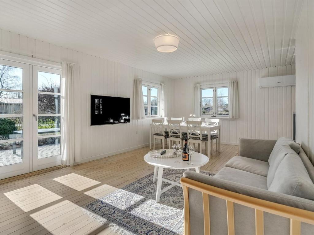 een woonkamer met een bank en een tafel bij Holiday Home Ghita - 1-2km from the sea in Sealand by Interhome in Hornbæk