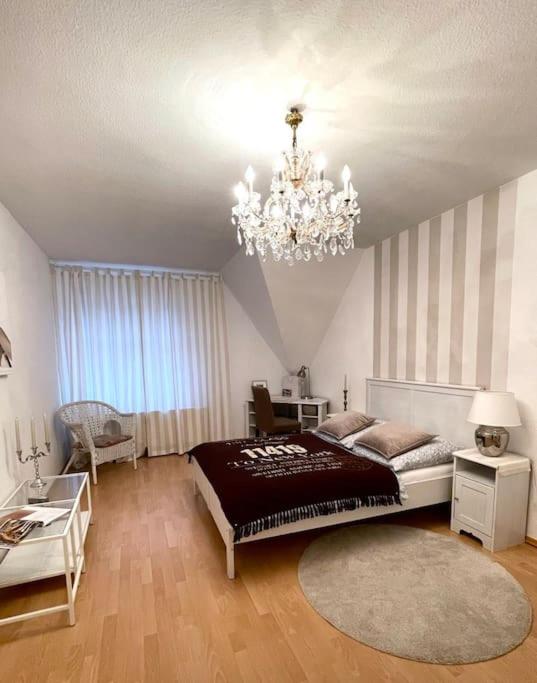 a bedroom with a large bed and a chandelier at Dachgeschosswohnung mit 2 Schlafzimmern Zentrum Nord mit Aufzug in Leipzig