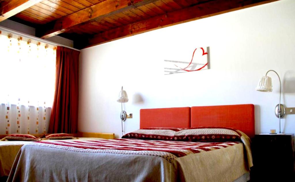 1 dormitorio con 1 cama con cabecero rojo en B&B La Betulla, en Rovereto