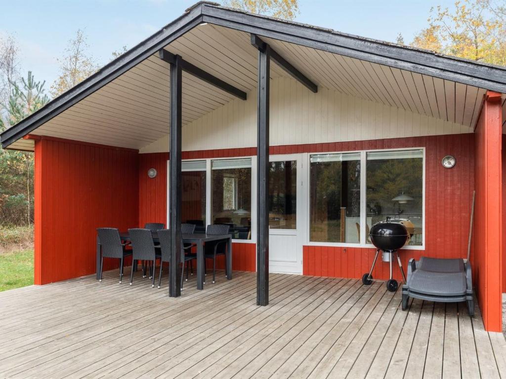 a house with a deck with a grill at Holiday Home Gerty - 300m from the sea in Bornholm by Interhome in Vester Sømarken
