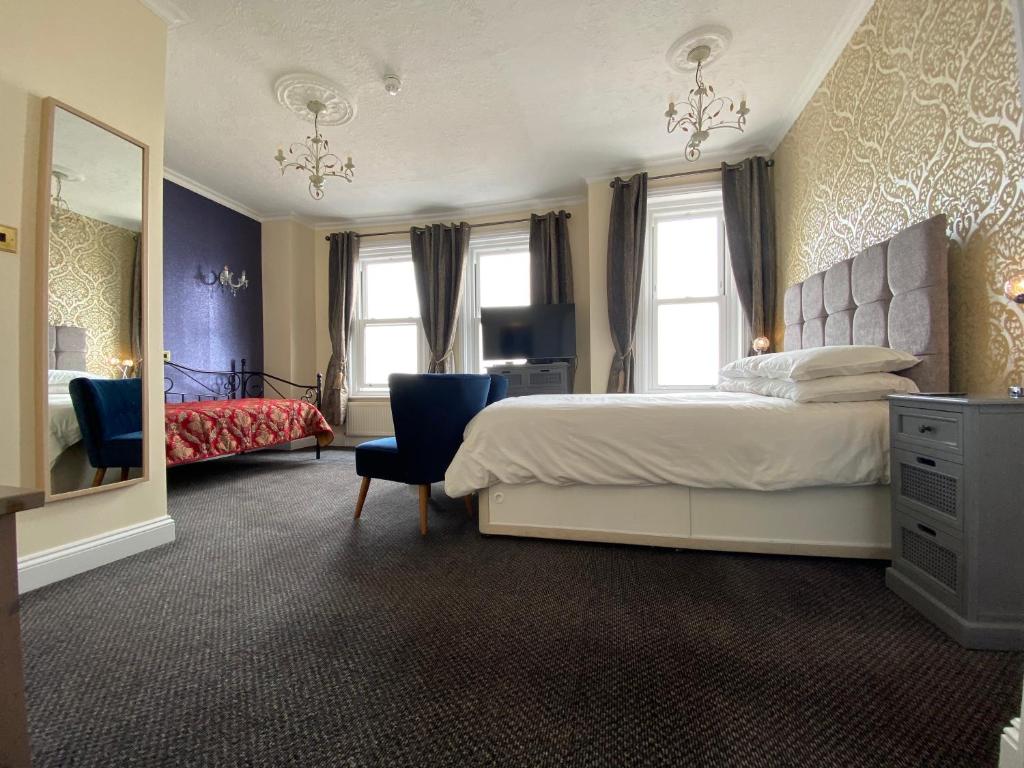 - une chambre avec un lit, une commode et un miroir dans l'établissement Atlanta, à Eastbourne