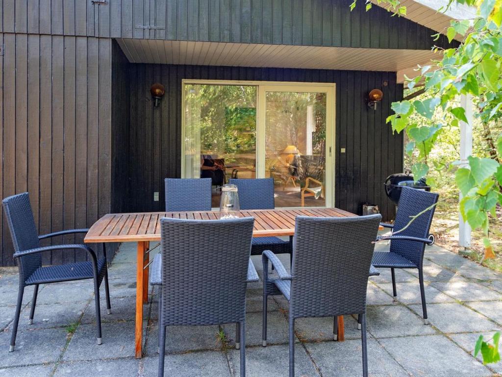 a wooden table and chairs on a patio at Holiday Home Hildegerd - 500m from the sea in Bornholm by Interhome in Vester Sømarken