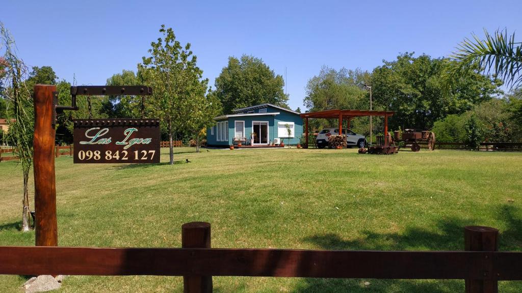 uma pequena casa azul com um sinal num campo em Las Igoa em Carmelo