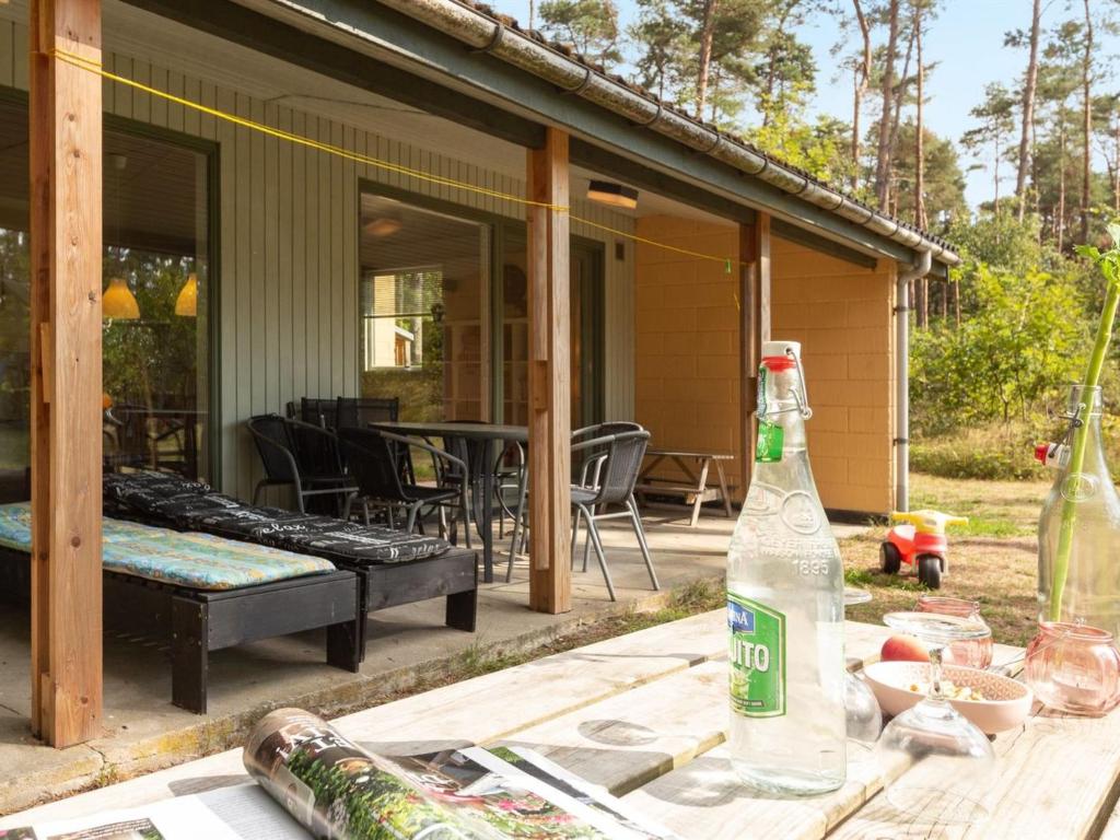 a bottle on a table in front of a house at Holiday Home Henri - 800m from the sea in Bornholm by Interhome in Neksø