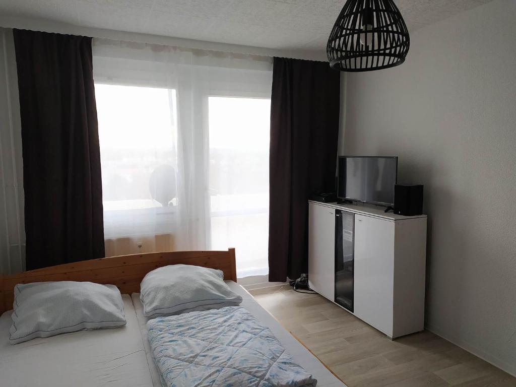 1 dormitorio con 1 cama y TV en un armario en Oederan One Room Apartment 33m2 Mindestens 1 Monat Reservierung, en Oederan