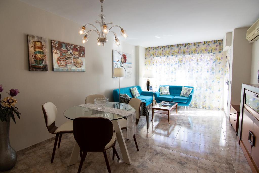 sala de estar con mesa y sofá azul en La Mirada 2, en Castellón de la Plana