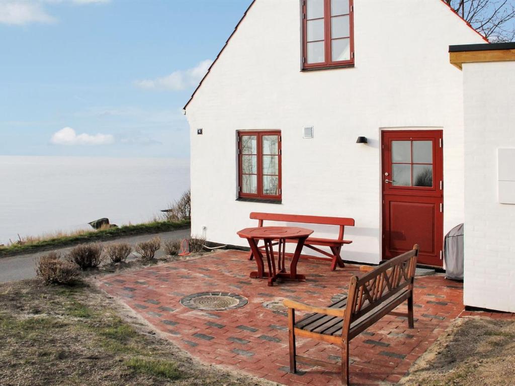 a table and benches in front of a white building at Holiday Home Uschi - 15m from the sea by Interhome in Hasle