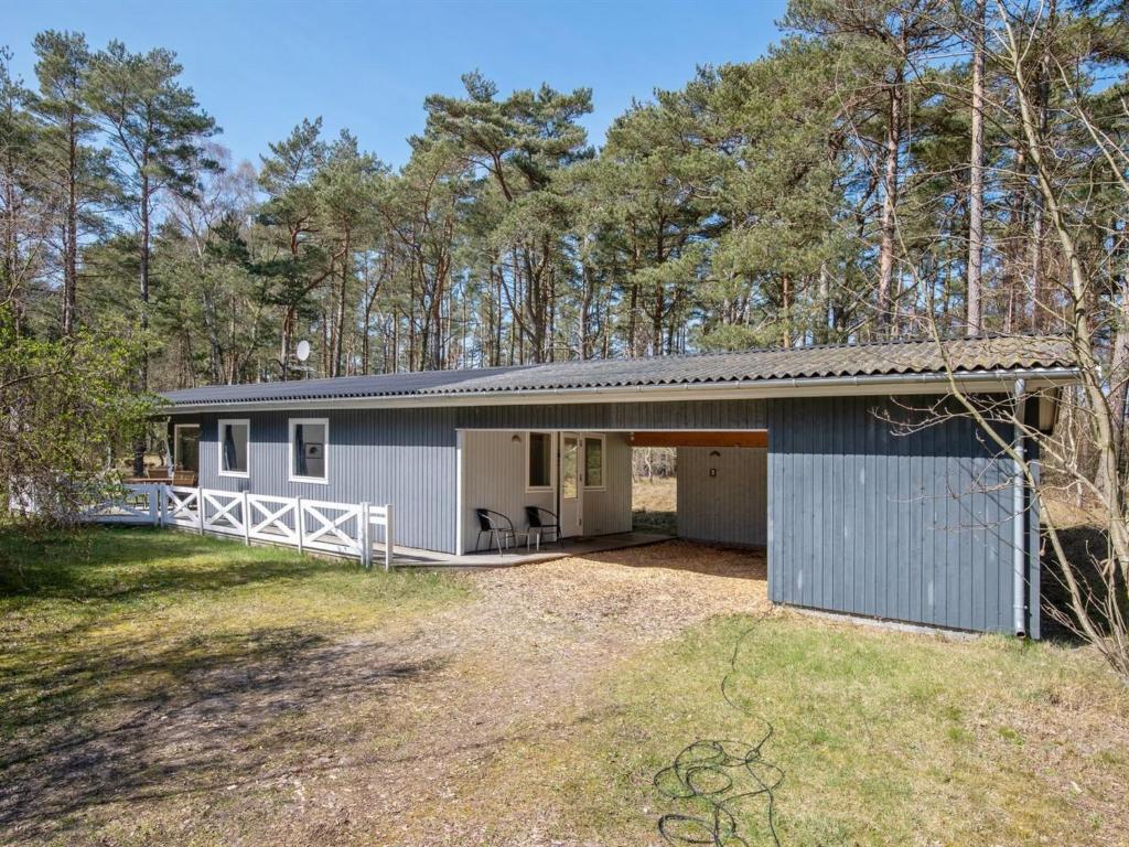 a house with a garage in the woods at Holiday Home Ludwik - 700m from the sea in Bornholm in Vester Sømarken