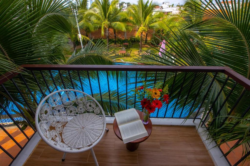 a balcony with a table and a chair and palm trees at Hung Vuong Resort in Phu Quoc