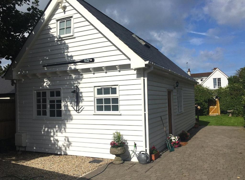 a small white building with a roof at Sea Rose Cottage in Kingsdown