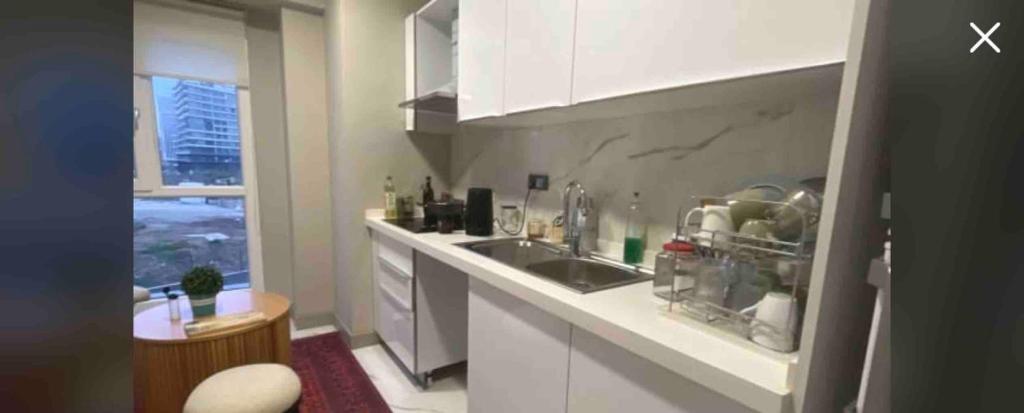 eine Küche mit weißen Schränken, einem Waschbecken und einem Fenster in der Unterkunft Private Room in Istanbul #68 in Istanbul