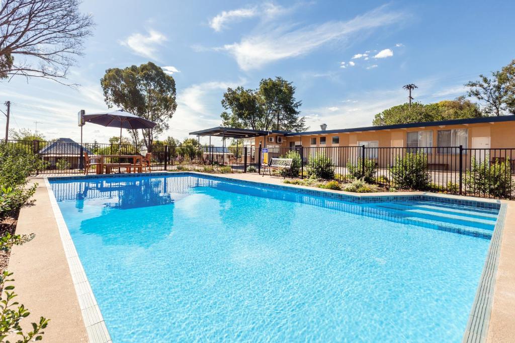 a swimming pool at a apartment complex with a building at Gulgong Motel in Gulgong