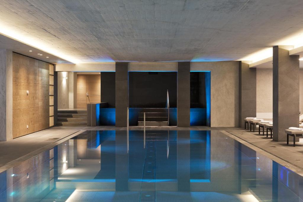 a swimming pool in a hotel lobby with blue lighting at ElisabethHotel Premium Private Retreat- Adults only in Mayrhofen